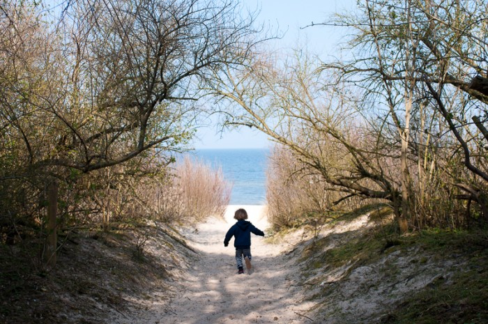 Child playing running towards the beach in Zinnowitz
