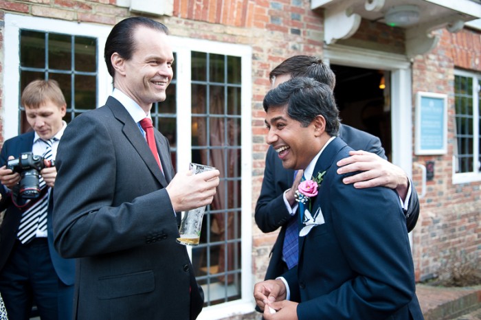 Documentary photograph of groom laughing with friends at Deans Place wedding