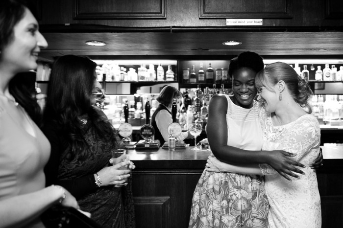 Bride laughing with friends at the bar at Deans Place wedding