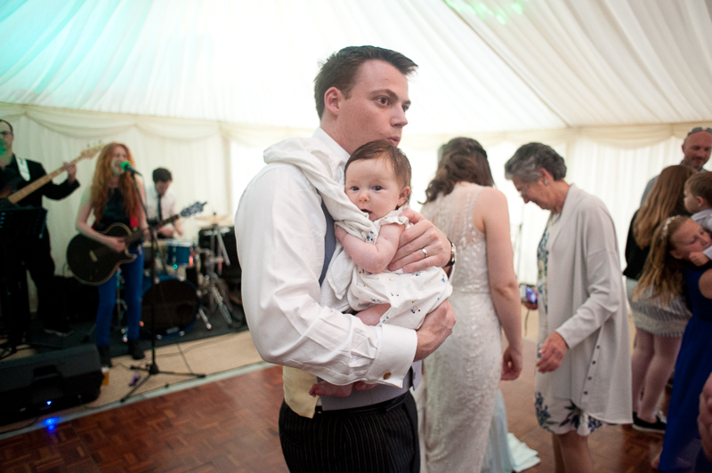 Groom dancing with baby at wedding at Ham House