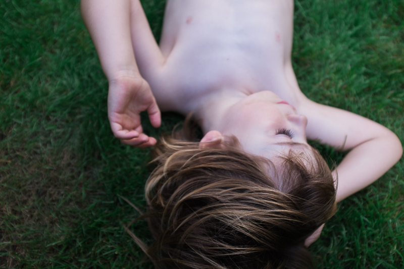 Child lying on the grass in Pancras Square