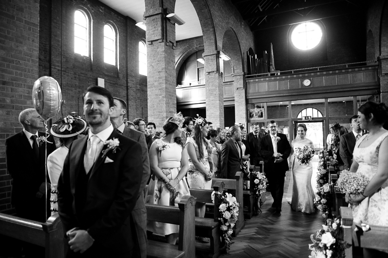 Bride walking down the aisle at wedding at Uxbridge church