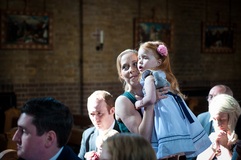 Little girl watching bride and groom walk down the aisle