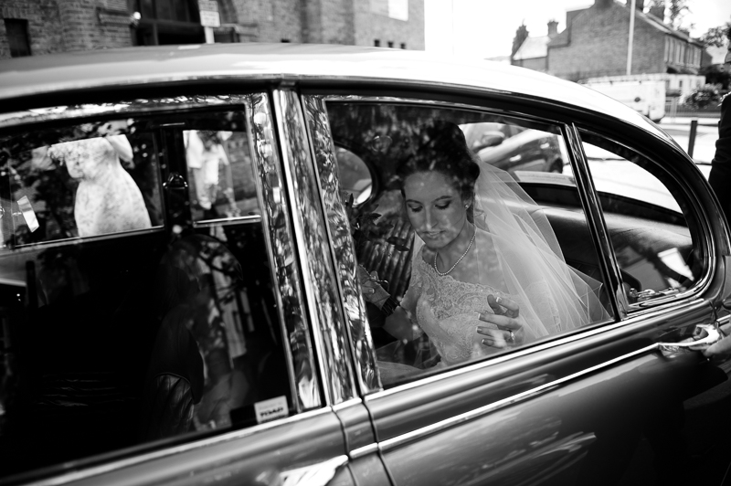 Artistic wedding photograph of bride in car