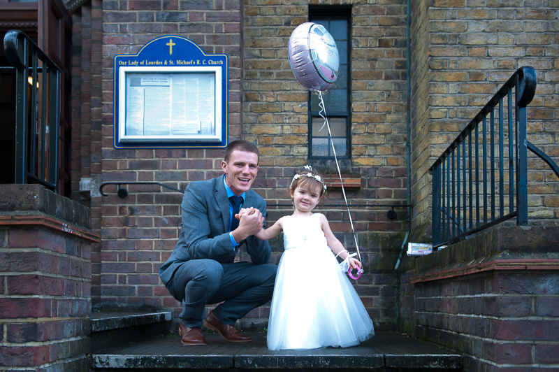 Flower girl greeting bride with balloon