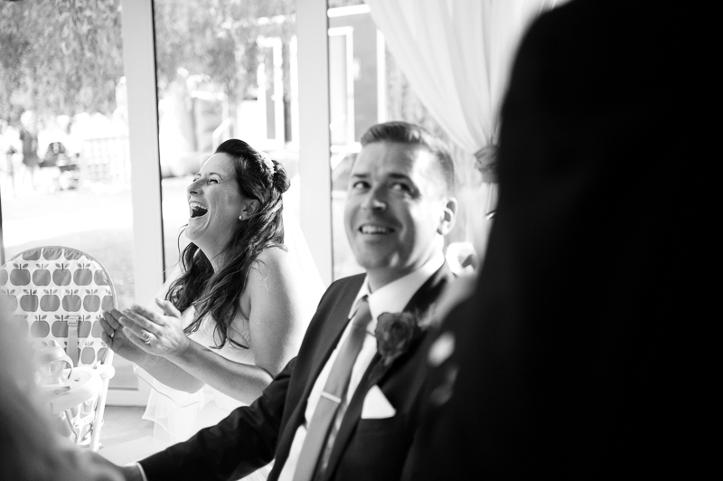 Bride and groom laughing during speeches