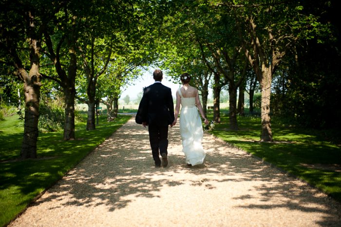 Bride and groom walking hand in hand at South Farm