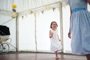 Child running around on dancefloor at child-friendly wedding