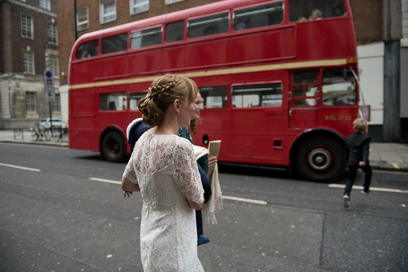 Bride gets on vintage red wedding bus outside Camden Town Hall