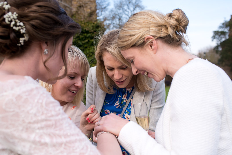 Bride's friends look at wedding ring at Cambridge Cottage