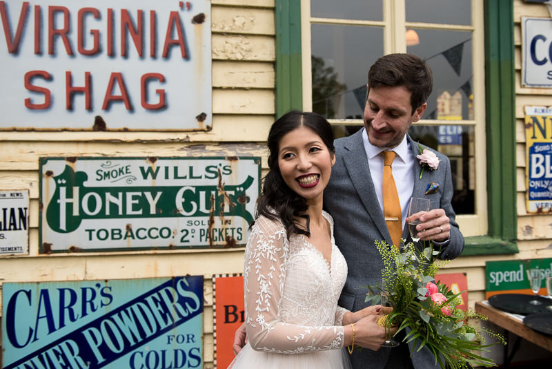 Bride and groom in front of colourful railway signs at Fawley Hill
