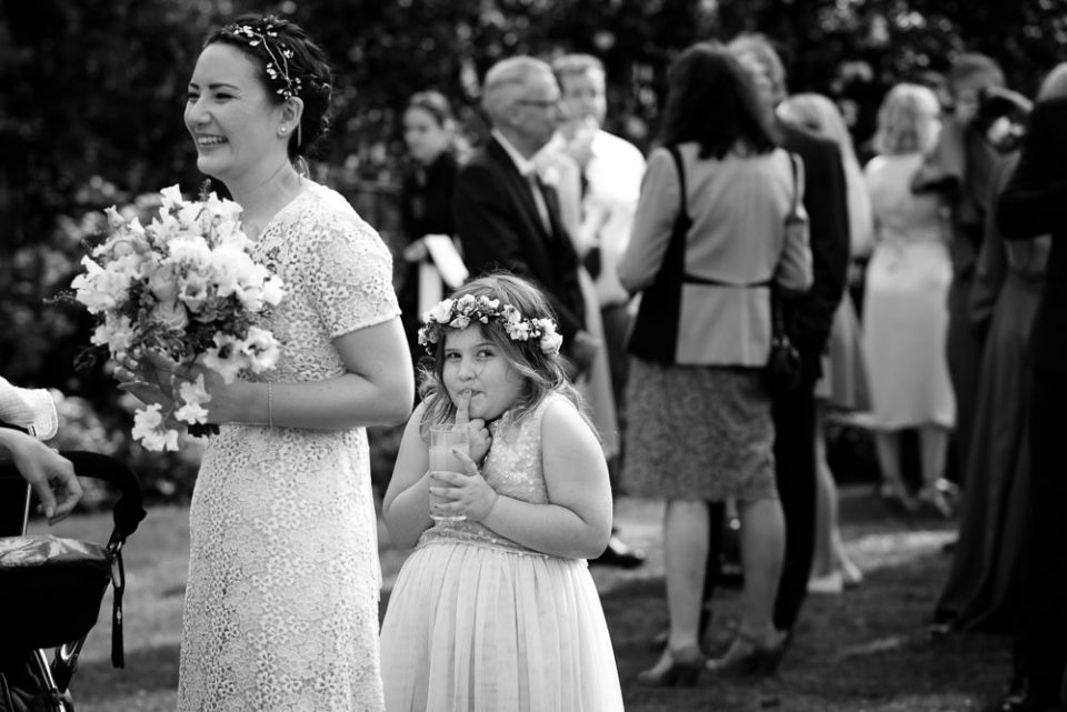 Black and white Gray's Inn Wedding Photography of flower girl hiding behind bride
