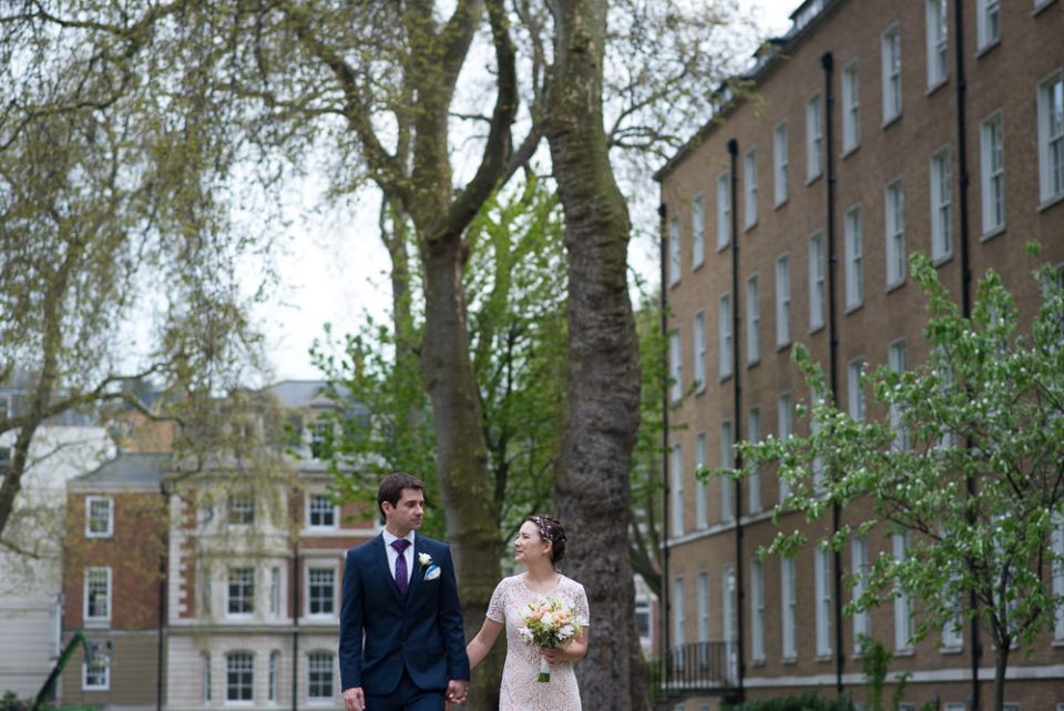 Bride and groom walk through the gardens at Gray's Inn