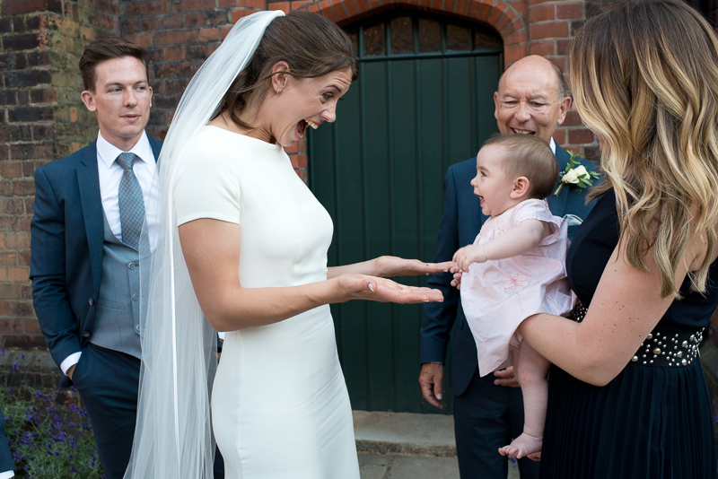 Bride with baby in courtyard at Fulham Palace