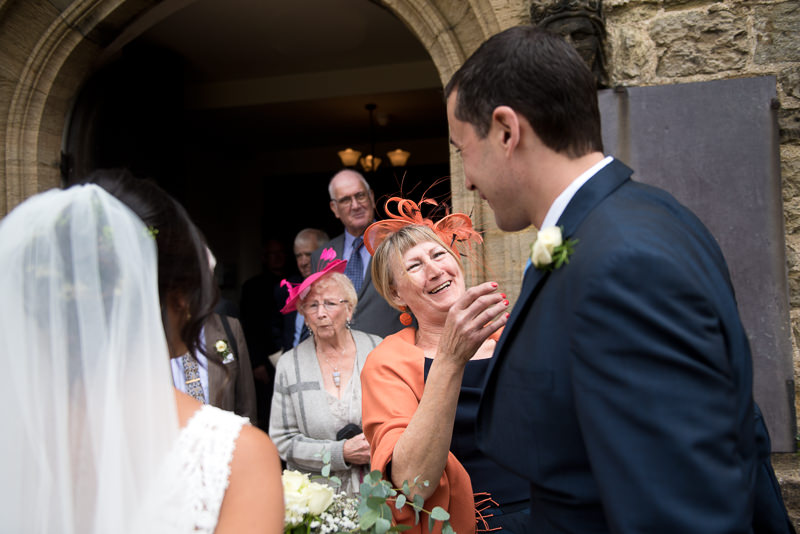 Bride greets guests outside St Mary's Church in Petworth