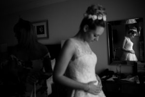 Pregnant bride puts on wedding dress