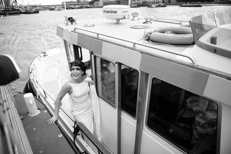 Black and white photograph of bride arriving at the HQS Wellington by River Taxi