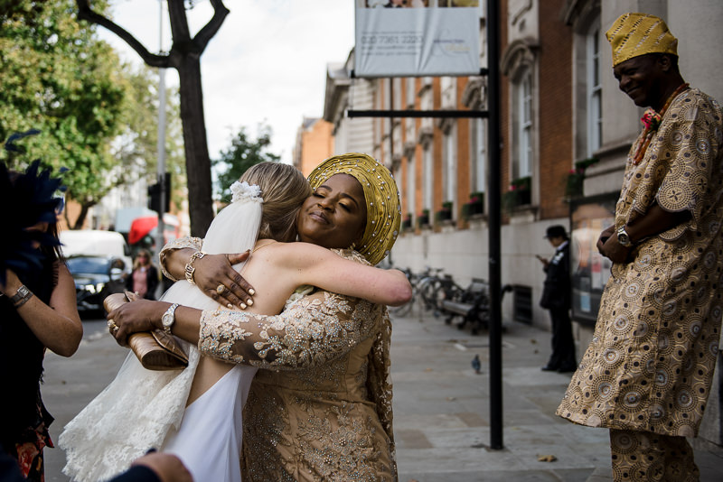 Bride hugs mother-in-law outside Chelsea Town Hall