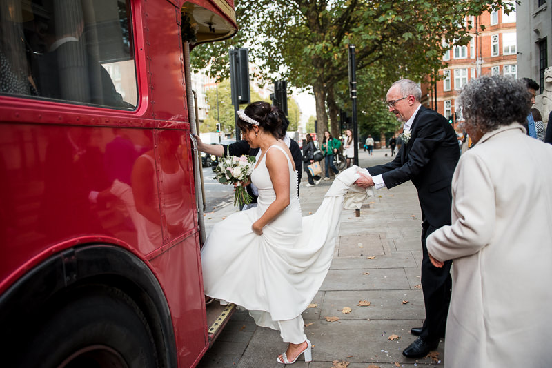 Bride gets on red London bus