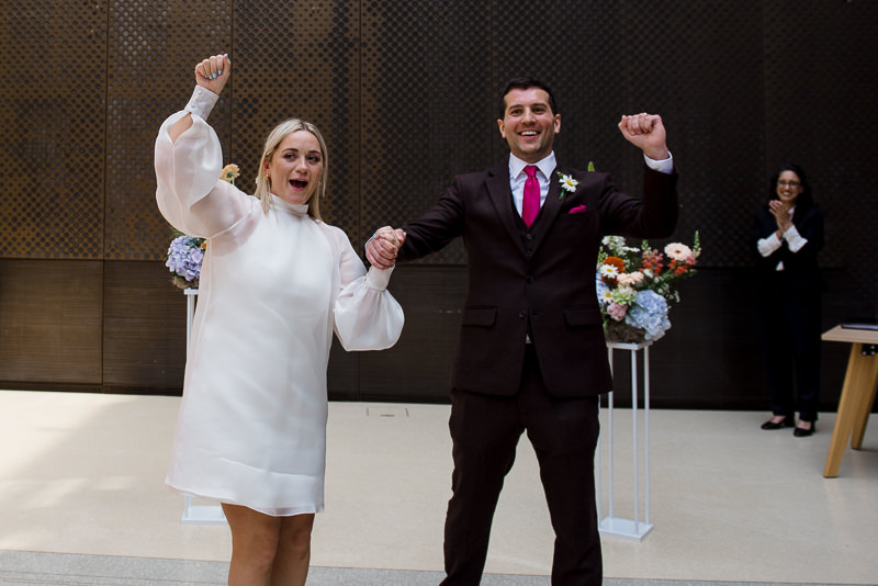 Bride and groom celebrate in the Atrium after Hackney Town Hall wedding