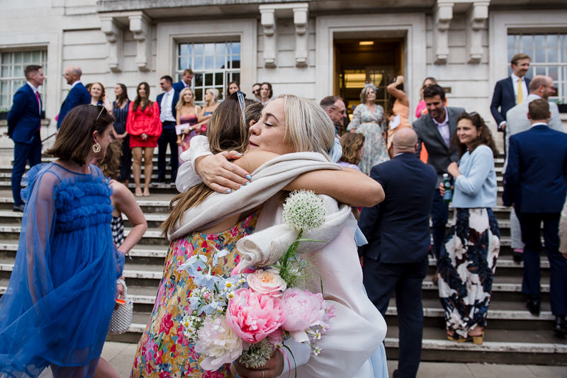Guests greet bride and groom outside Hackney Town Hall